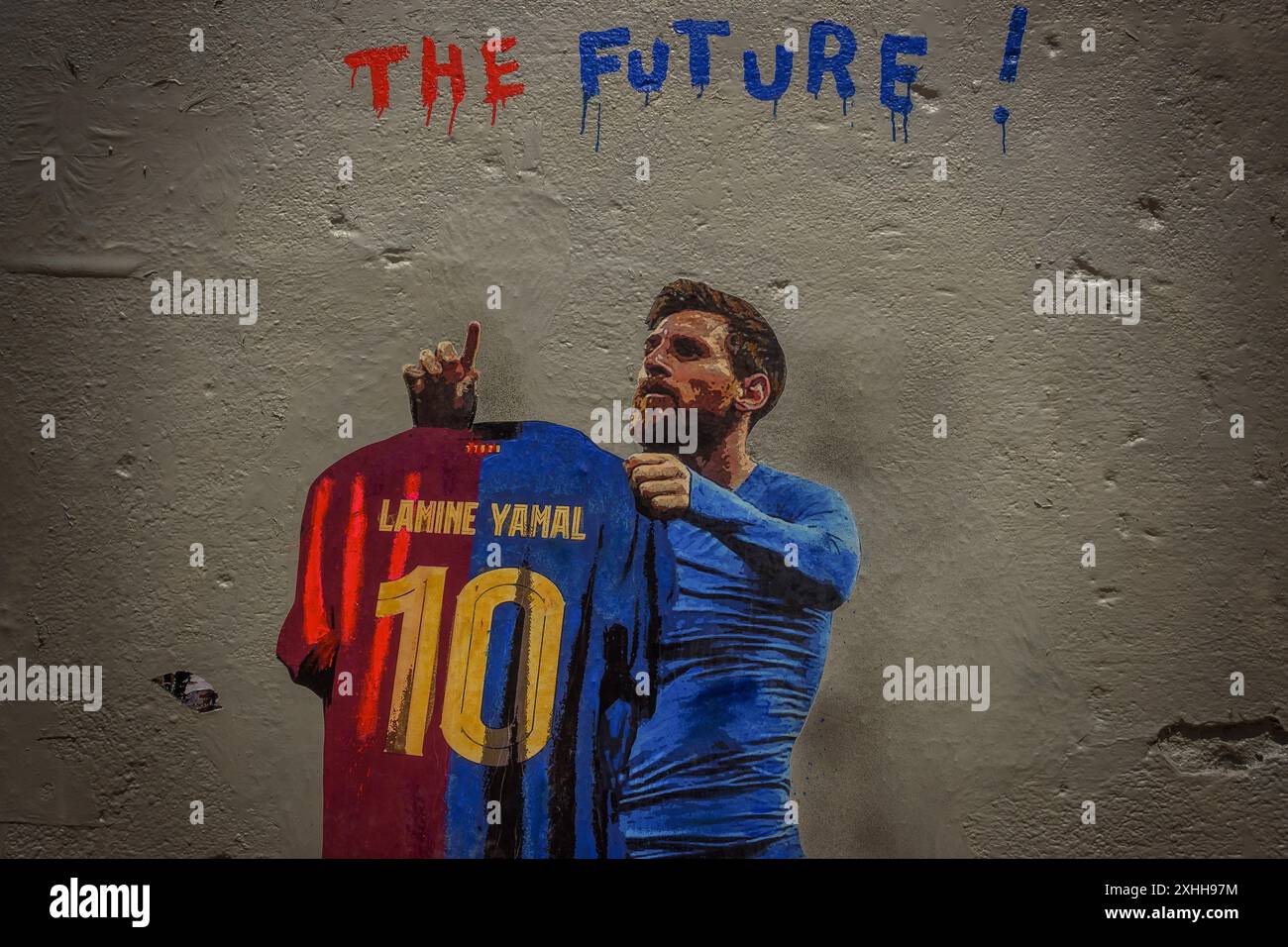 Barcelone, Espagne. 14 juin 2024. Un voyageur passe devant une murale de l'artiste urbain italien 'TVBoy', Salvatore Benintende. Intitulé « The future », le graffiti représente Lionel Messi portant un maillot du FC Barcelone avec son ancien numéro 10 et le nom Lamine Yamal, présentant la jeune star le jour où il pourrait devenir le plus jeune vainqueur d'un championnat de l'UEFA Euro, en tant que successeur. Crédit : Matthias Oesterle/Alamy Live News Banque D'Images