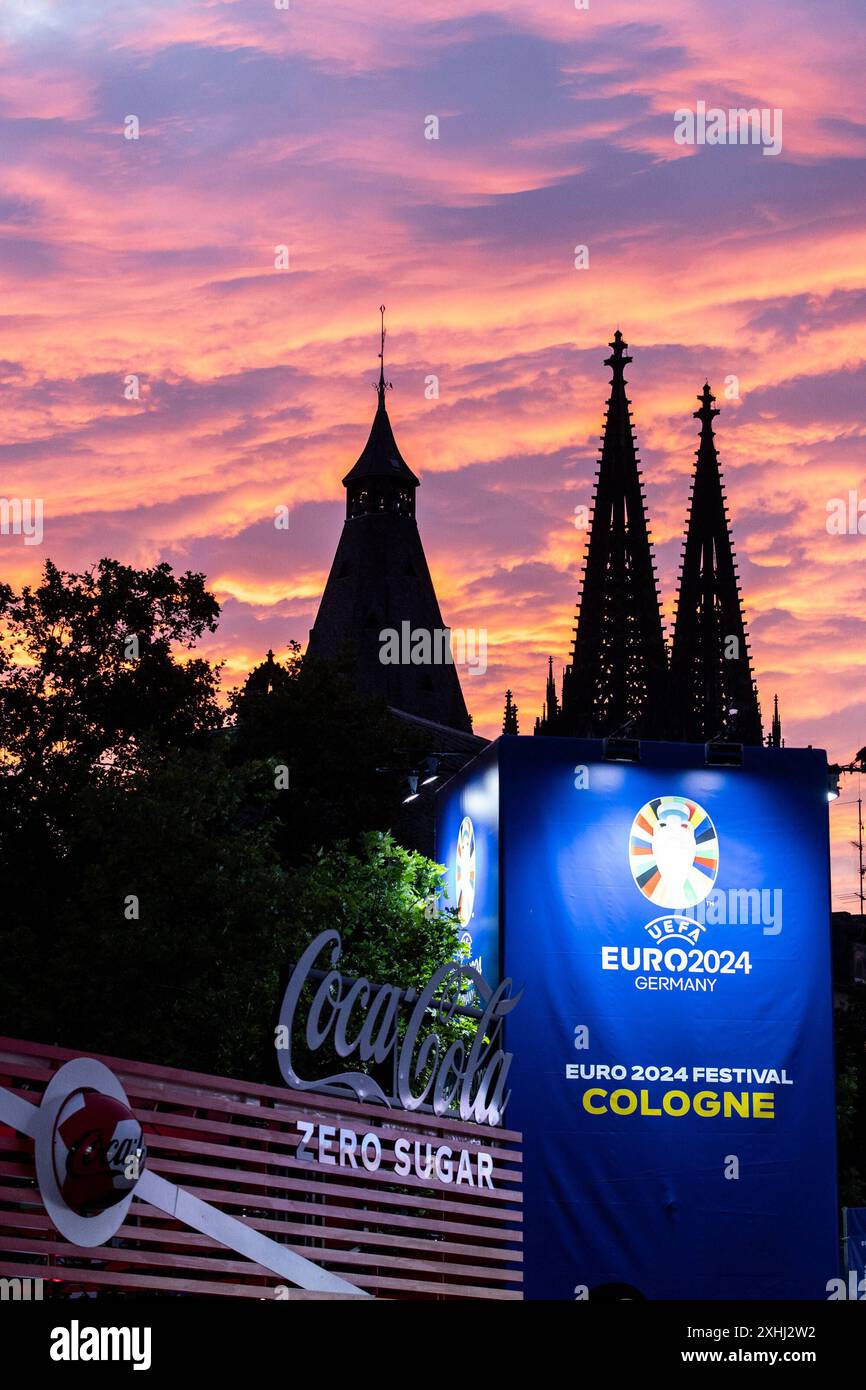 Public Viewing in Köln Fan-zone am Heumarkt Köln 14.07.2024 Blick auf Kölner Dom, Sonnenuntergang, logo von UEFA EURO 2024 auf dem Schild neben Eingang. Visite publique à Köln Fan-zone am Heumarkt Köln 14.07.2024 Köln Heumarkt NRW Deutschland *** visite publique à Cologne Fan-zone à Heumarkt Cologne 14 07 2024 vue de la cathédrale de Cologne, coucher de soleil, logo UEFA EURO 2024 sur le panneau à côté de l'entrée public visionnement dans la zone des fans de Cologne au Heumarkt Cologne 14 07 2024 Cologne Heumarkt NRW Allemagne Copyright : xBEAUTIFULxSPORTS/Buriakovx Banque D'Images