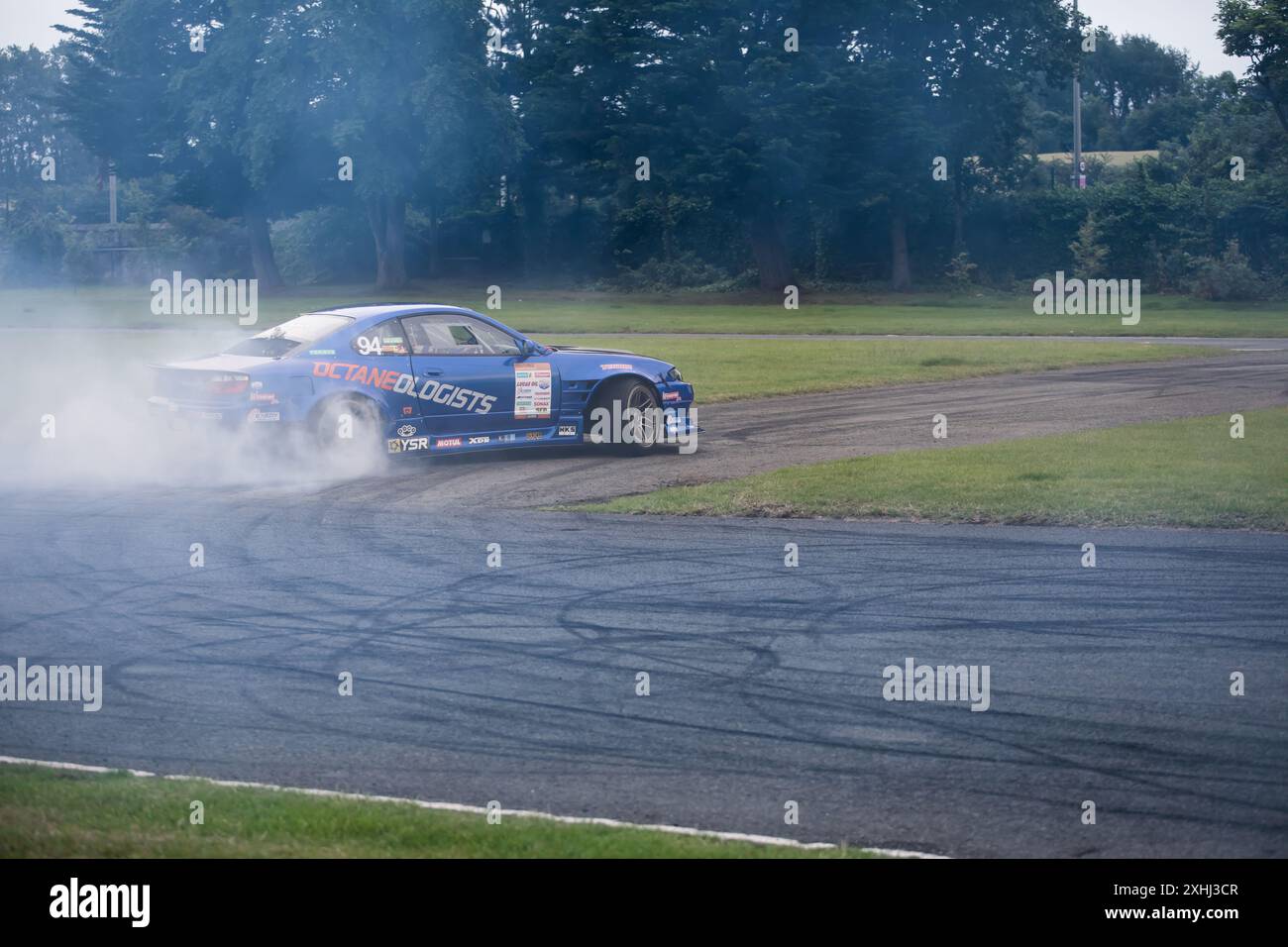 Voiture bleue brillante dérivant autour d'une piste de course Banque D'Images