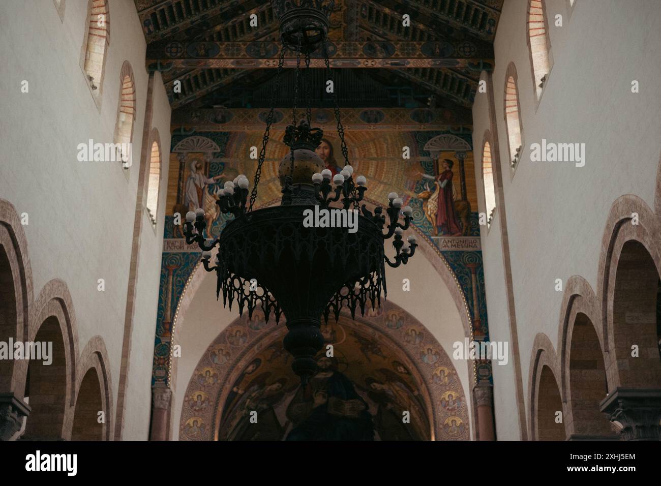 Vue intérieure d'une cathédrale historique dotée de fenêtres cintrées, d'un plafond orné et d'un grand lustre Banque D'Images