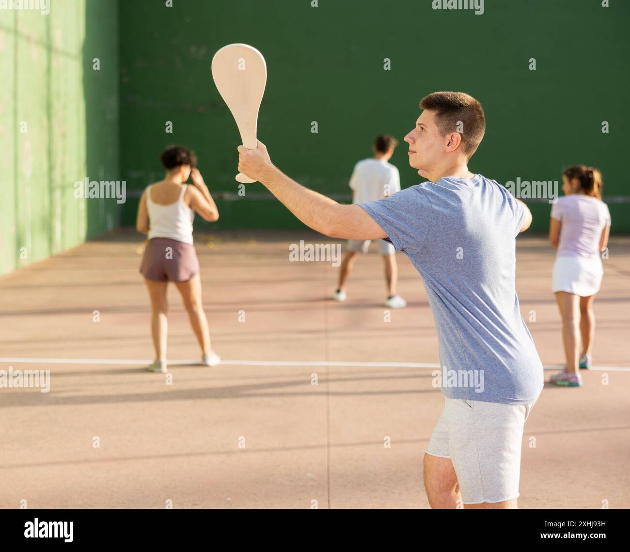 Jeune homme servant le ballon pendant le jeu de pelota à l'extérieur Banque D'Images