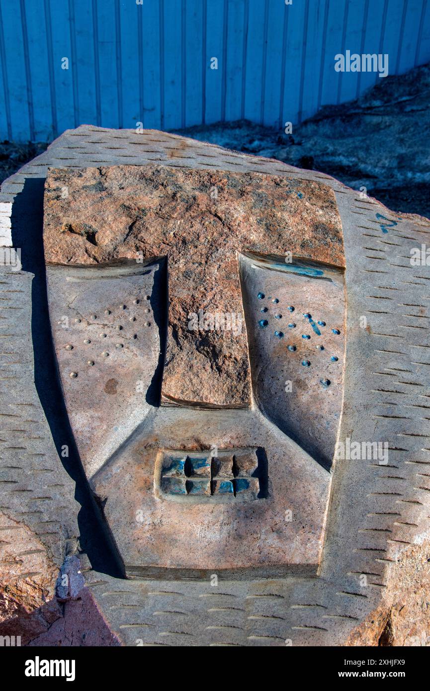 Sculptures en pierre de visages masqués sur un rocher au parc de sculptures Inuit près des four Corners à Iqaluit, Nunavut, Canada Banque D'Images