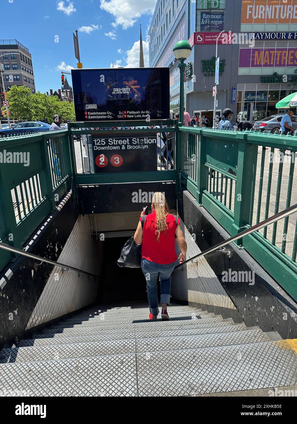 Femme entrant dans la station de métro de la 125e rue du centre-ville dans la section Harlem de Manhattan à New York Banque D'Images