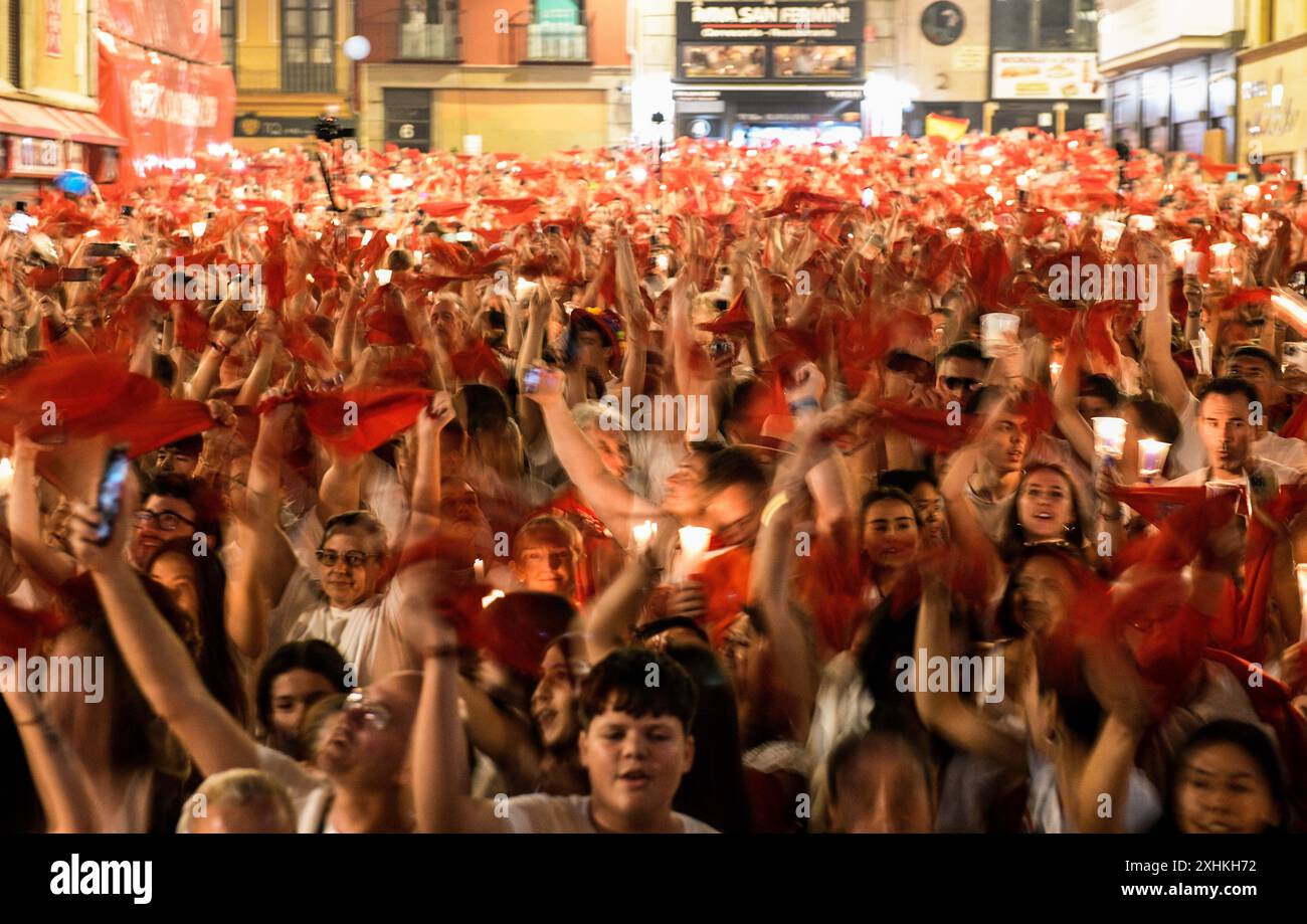 Pampelune, 14 juillet 2024. Les fêtards brandissent des foulards rouges et des bougies alors qu'ils se rassemblent devant la mairie de la ville pour chanter la chanson d'adieu traditionnelle 'Pobre de mi' (pauvre moi) qui symbolise leur tristesse pour la fin du festival San Fermin, à Pampelune, dans le nord de l'Espagne, le 15 juillet 2024. Crédit : Mikel CIA Da Riva /Alamy Live News Banque D'Images Pampelune, 14 juillet 2024. Les fêtards brandissent des foulards rouges et des bougies alors qu'ils se rassemblent devant la mairie de la ville pour chanter la chanson d'adieu traditionnelle 'Pobre de mi' (pauvre moi) qui symbolise leur tristesse pour la fin du festival San Fermin, à Pampelune, dans le nord de l'Espagne, le 15 juillet 2024. Crédit : Mikel CIA Da Riva /Alamy Live News Banque D'Images