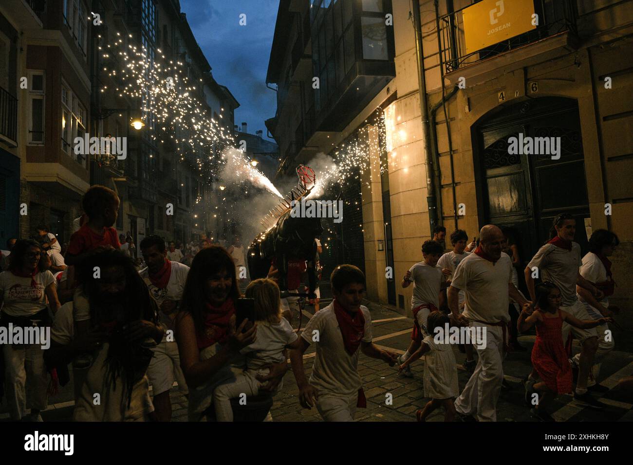 Pampelune, 14 juillet 2024. Les fêtards sont couverts d'étincelles du 'Fire Bull', un homme portant une structure métallique chargée de feux d'artifice le cinquième jour du festival San Fermin à Pampelune le 14 juillet 2024. Crédit : Mikel CIA Da Riva /Alamy Live News Banque D'Images Pampelune, 14 juillet 2024. Les fêtards sont couverts d'étincelles du 'Fire Bull', un homme portant une structure métallique chargée de feux d'artifice le cinquième jour du festival San Fermin à Pampelune le 14 juillet 2024. Crédit : Mikel CIA Da Riva /Alamy Live News Banque D'Images