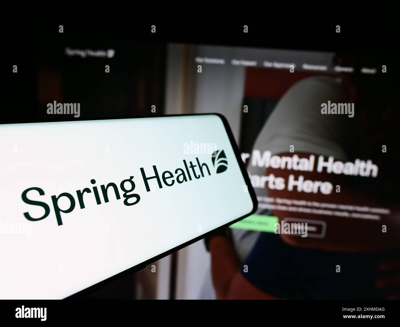 Téléphone portable avec le logo de la société américaine de santé mentale Spring Care Inc devant le site Web de l'entreprise. Mettez l'accent sur le centre-gauche de l'écran du téléphone. Banque D'Images