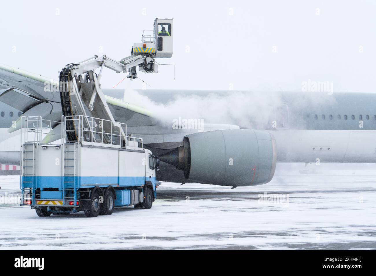 Dégivrage de l'avion avant le vol. La machine de dégivrage saupoudre l'aile d'un avion de passagers d'antigel. Hiver à l'aéroport. Neige. Manutention aérienne. Vapeur dans le froid. Service aéroport Banque D'Images