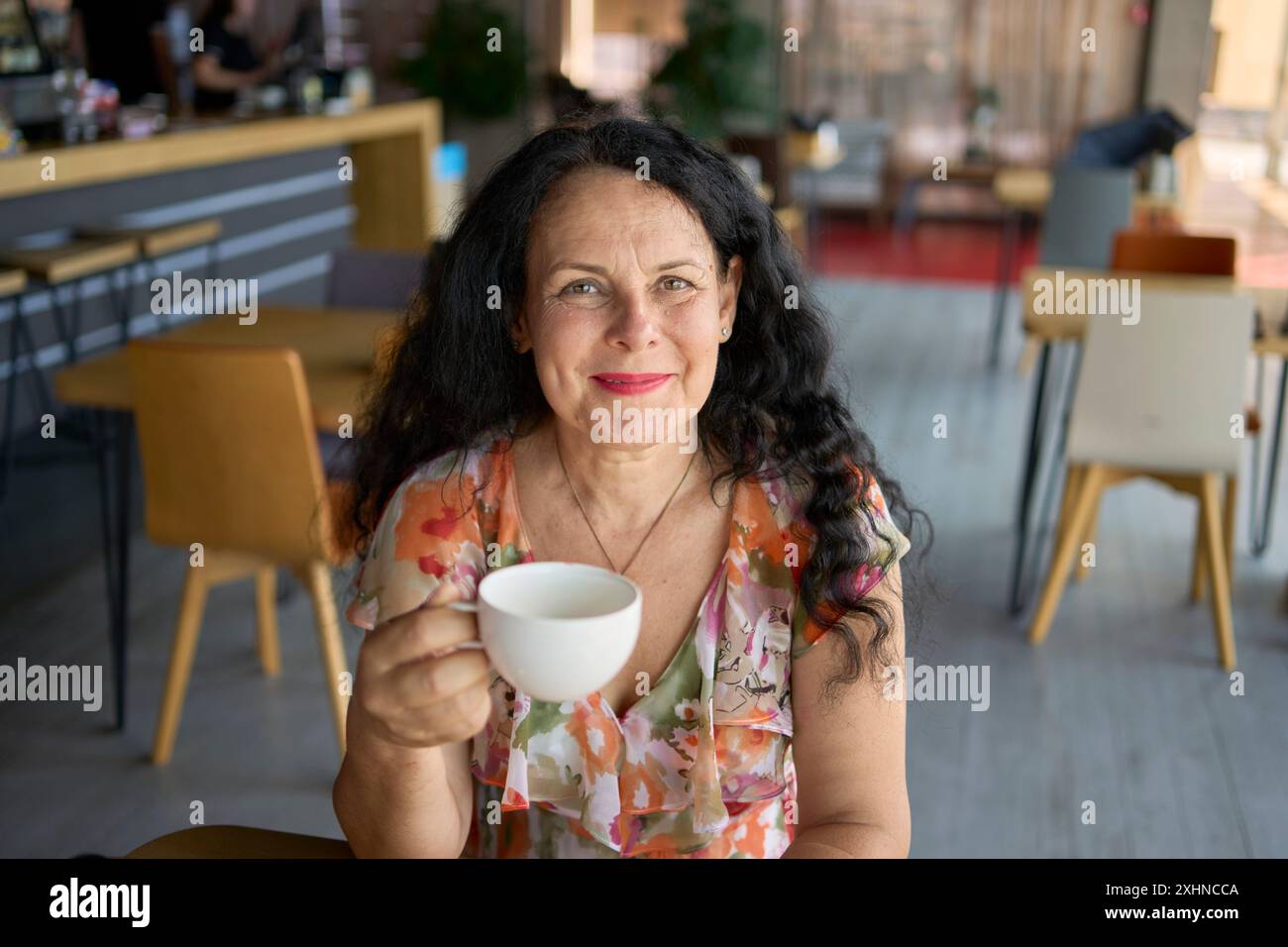 une femme des années 60 buvant du thé d'ortie dans un bureau de coworking moderne pendant la pause déjeuner Banque D'Images