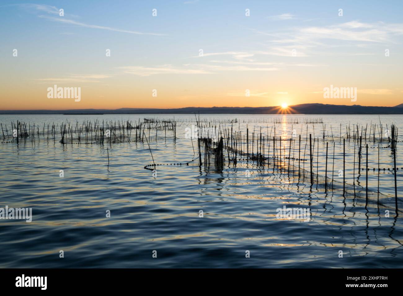 Belle vue sur la albufera au coucher du soleil avec filets de pêche à Valence, Espagne Banque D'Images