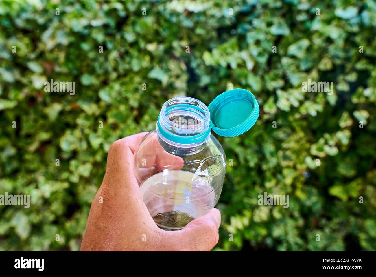 Nago-Torbole, Lac de Garde, Italie - 15 juillet 2024 : tenir à la main une bouteille de boisson avec un couvercle attaché, une mesure innovante pour réduire les déchets plastiques et promouvoir le recyclage. Obligatoire à partir de juillet *** hand hält eine Getränkeflasche mit festhängendem Deckel, eine Innovative Maßnahme zur Reduzierung von Plastikmüll und Förderung des Recyclings. AB Juli verpflichtend Banque D'Images