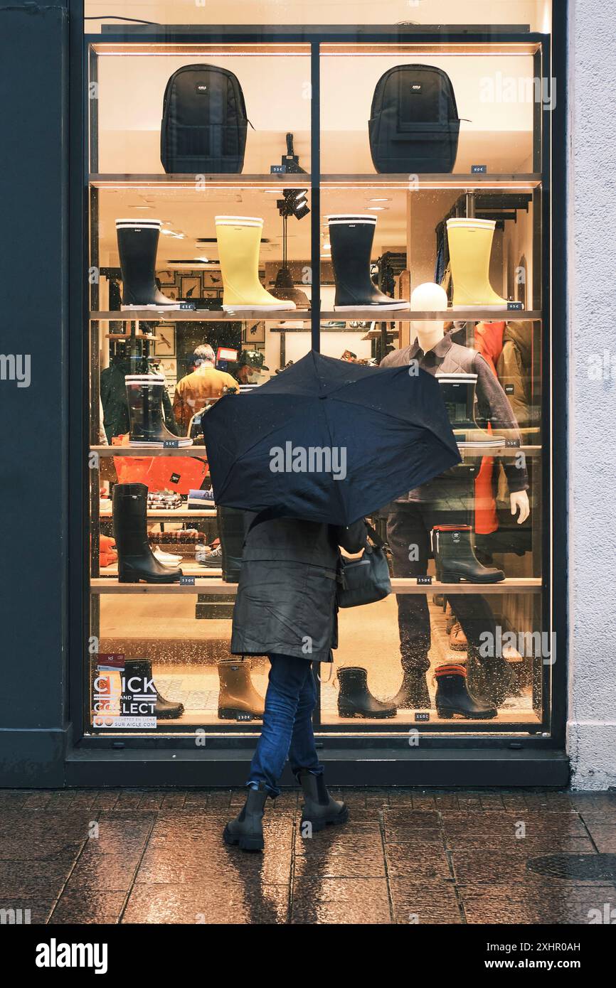 France, Finistère, Brest, par temps pluvieux, un homme regarde une fenêtre de magasin de chaussures sur la rue de Siam Banque D'Images