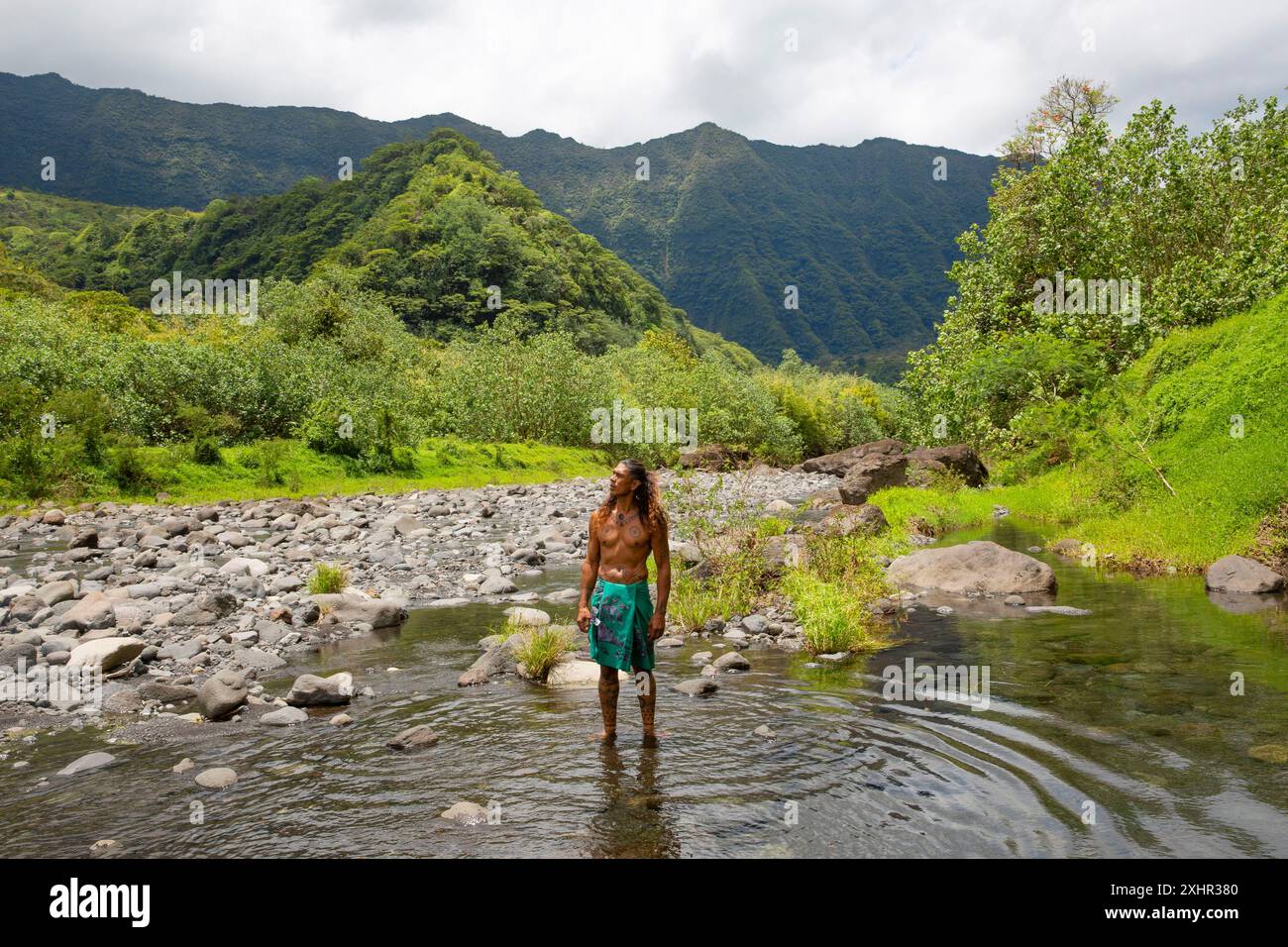 Polynésie française, île de Tahiti, vallée de Papenoo, Teuai Lenoir, guide polynésien couvert de tatouages traditionnels et vêtu d'un pagne avec son f Banque D'Images