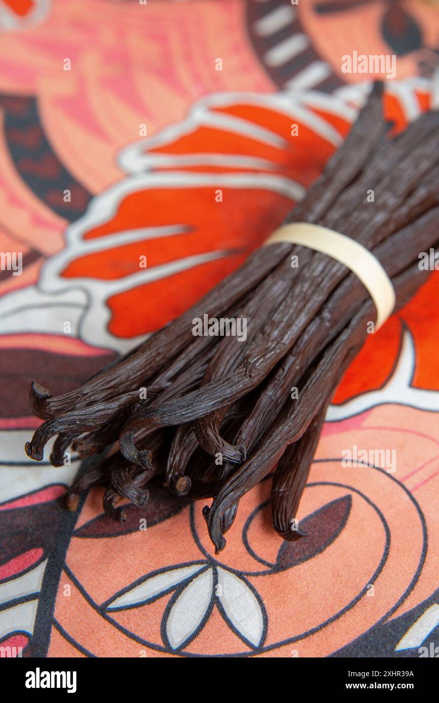 Polynésie française, île de Taha'a, paquet de gousses de vanille de Taha'a posées sur un tissu aux motifs polynésiens traditionnels Banque D'Images
