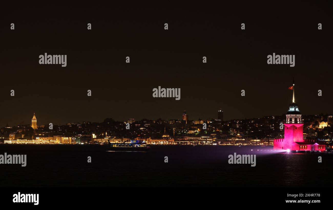 Une photographie de nuit et longue exposition capture un spectacle de lumière synchronisé entre la Tour de la jeune fille (Kız Kulesi) et la Tour Galata à Istanbul. Banque D'Images