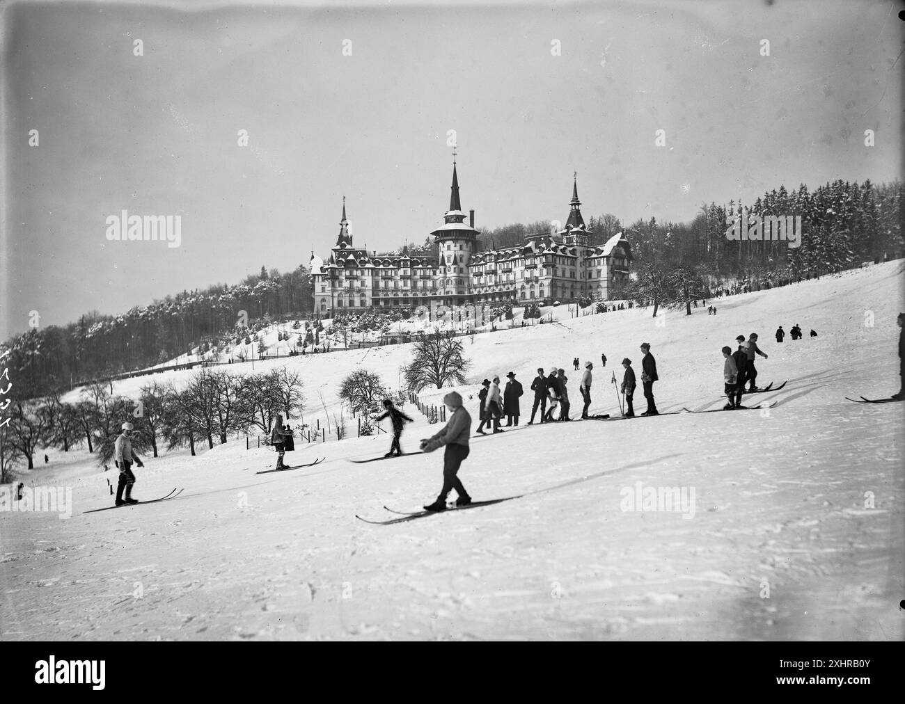 Vue extérieure du Grand Hôtel Dolder dans un paysage hivernal, vue de loin. Au premier plan skieurs sur les pistes dans les Alpes suisses. Photographie d'alpinisme historique suisse vintage, 1910, crédit photo : inconnu Banque D'Images