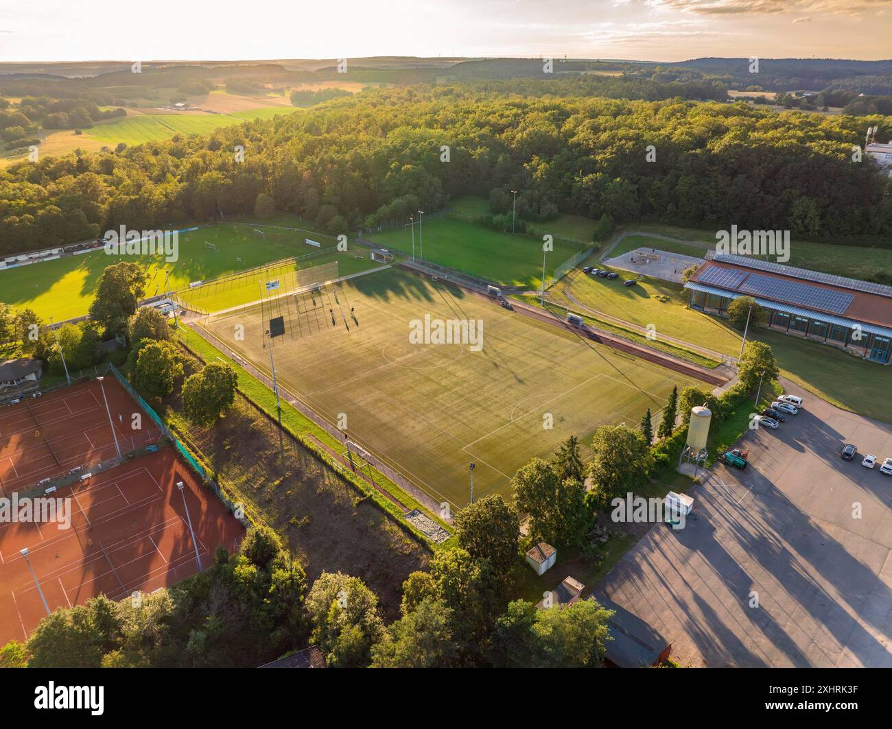 Vue aérienne des terrains de sport et des bâtiments au crépuscule entouré par la nature, Gechingen, Forêt Noire, Allemagne Banque D'Images