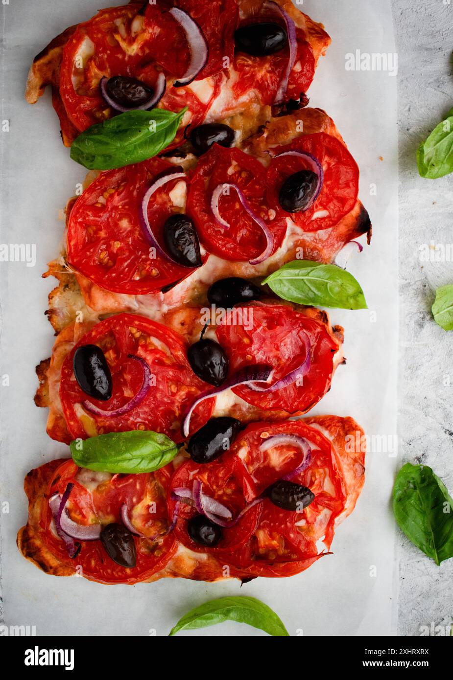 Bruschetta savoureuse à la mozzarella, tomates, olives noires et basilic sur un papier cuisson brun. Set d'encas italiens antipasti. Banque D'Images