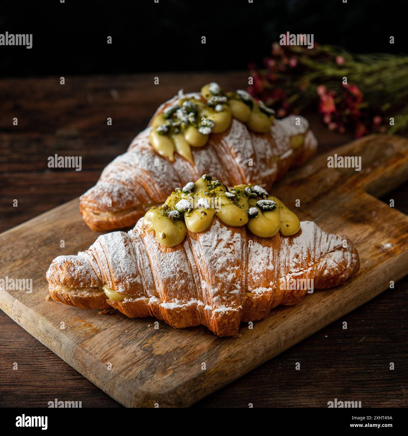 Croissants gourmands à la pistache fraîchement cuits sur un fond wodden. Style de vie du café-restaurant. Banque D'Images