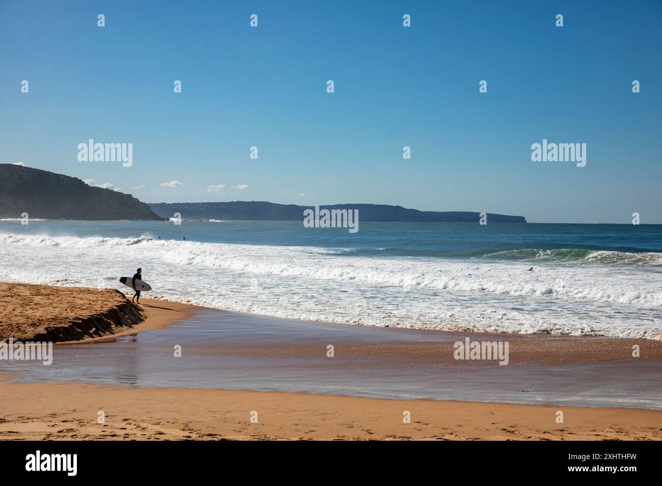 Surfeur australien solitaire marchant avec planche de surf, Palm Beach à Sydney, Australie Banque D'Images