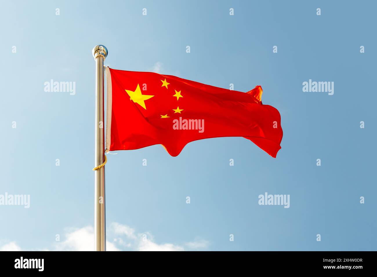 Le drapeau de la Chine se rapproche. Le drapeau chinois rouge à cinq étoiles est contre le ciel bleu. Banque D'Images