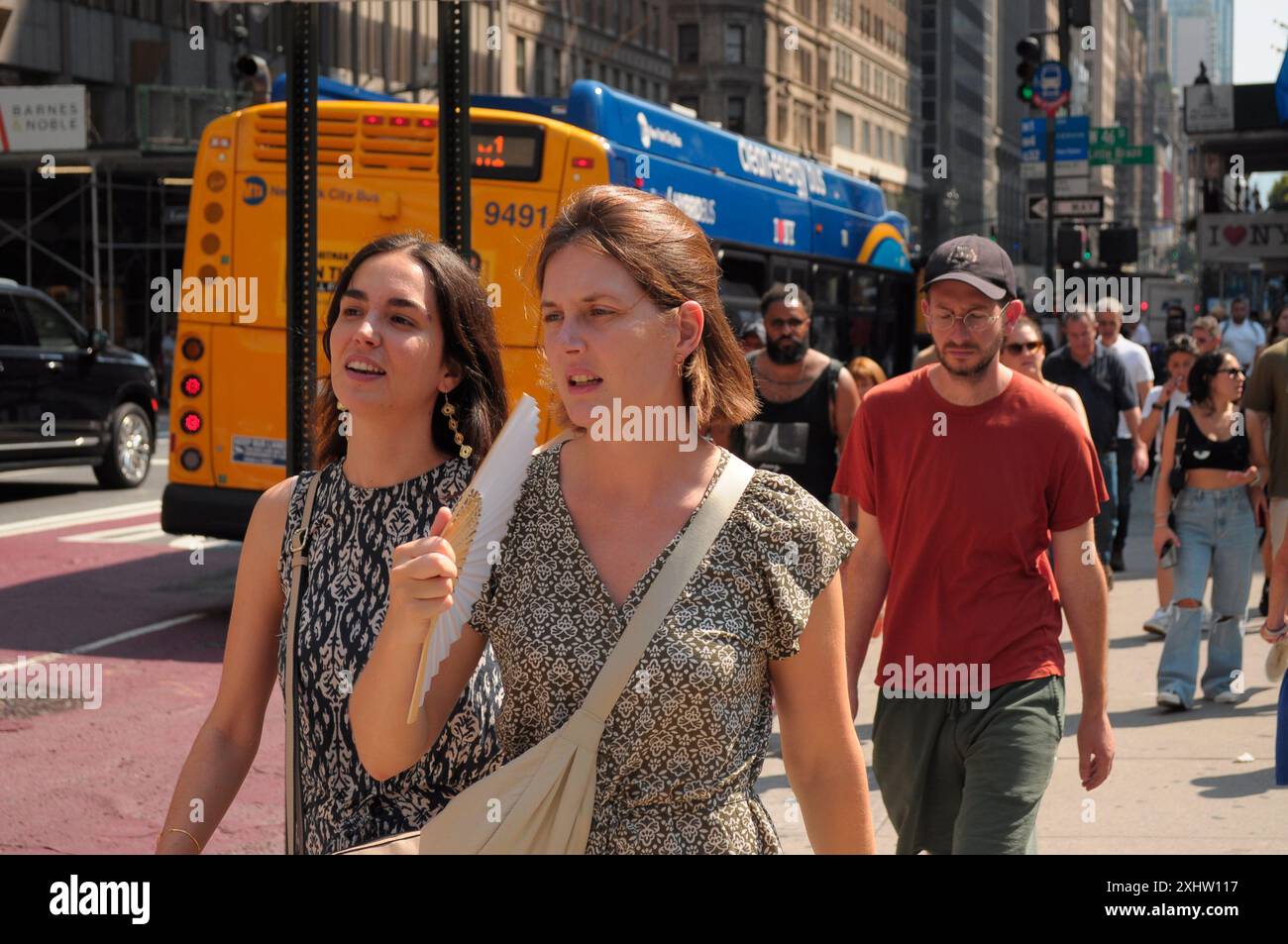 New York, États-Unis. 15 juillet 2024. Une personne utilise un ventilateur en traversant la rue pendant la troisième vague de chaleur de l'été à Manhattan, New York. Les New-Yorkais connaissent des températures élevées dans les années 90 avec un temps humide qui rend le temps plus chaud. Les avis météorologiques incitent les gens à rester au frais et hydratés par temps chaud. Crédit : SOPA images Limited/Alamy Live News Banque D'Images