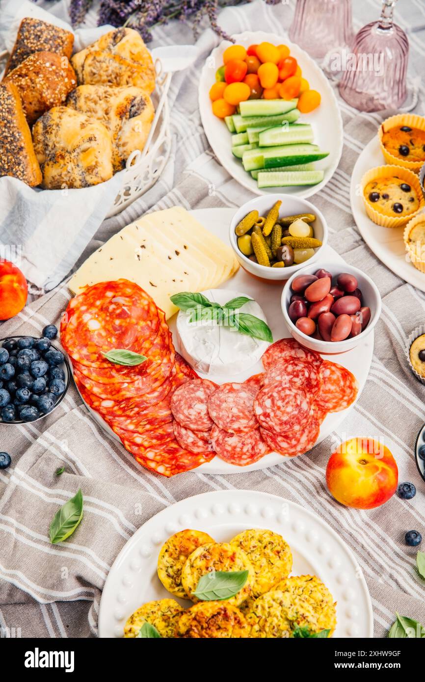 Pique-nique, hors-d'œuvre et plateau de fromage et de viande avec muffins sucrés et salés et fruits Banque D'Images