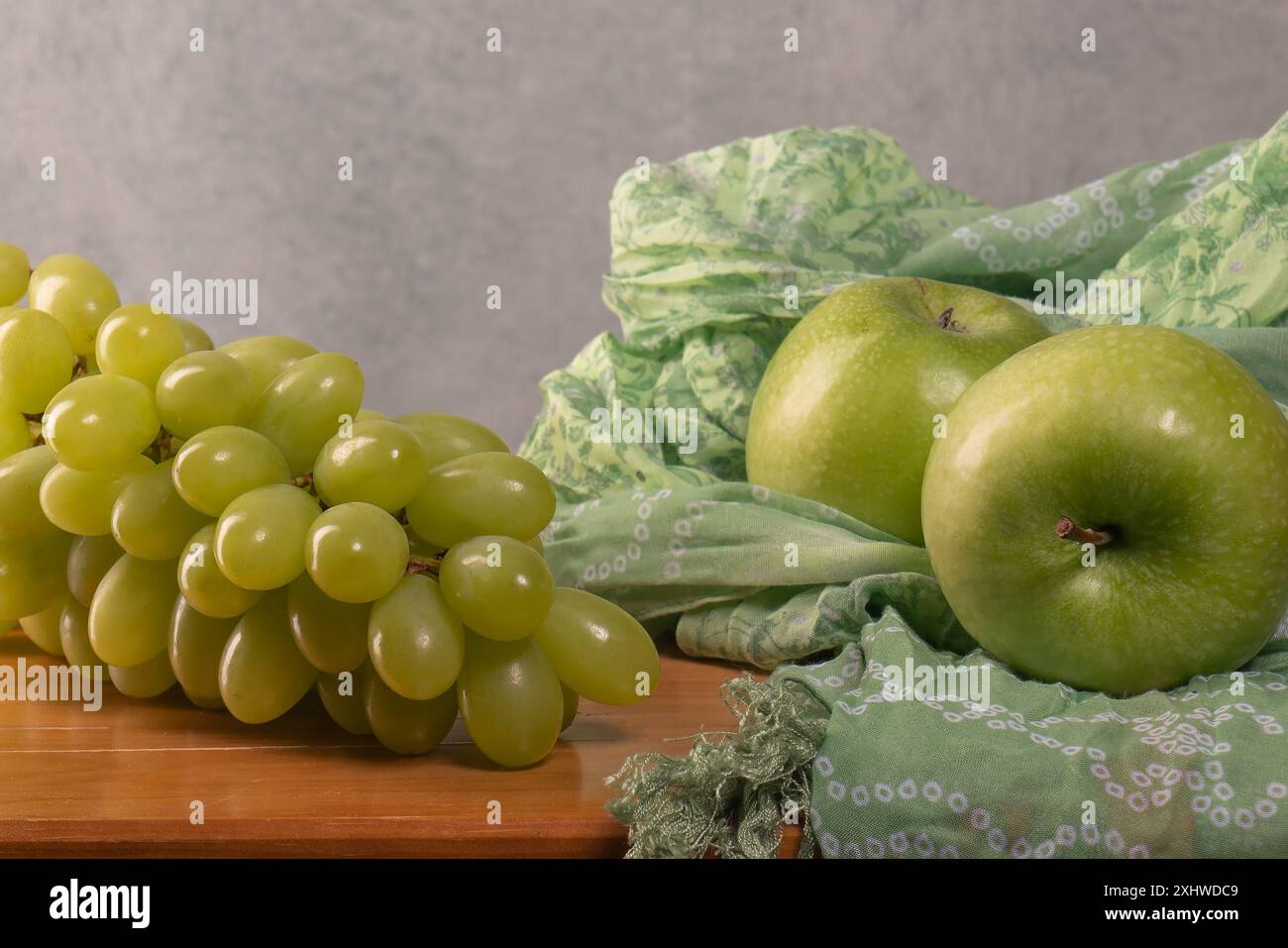 Deux pommes vertes, un gros bouquet de raisins verts sur une table en bois. Une nutrition adéquate. régime vitaminique. Excès de poids. Vegan. Beau corps. Banque D'Images