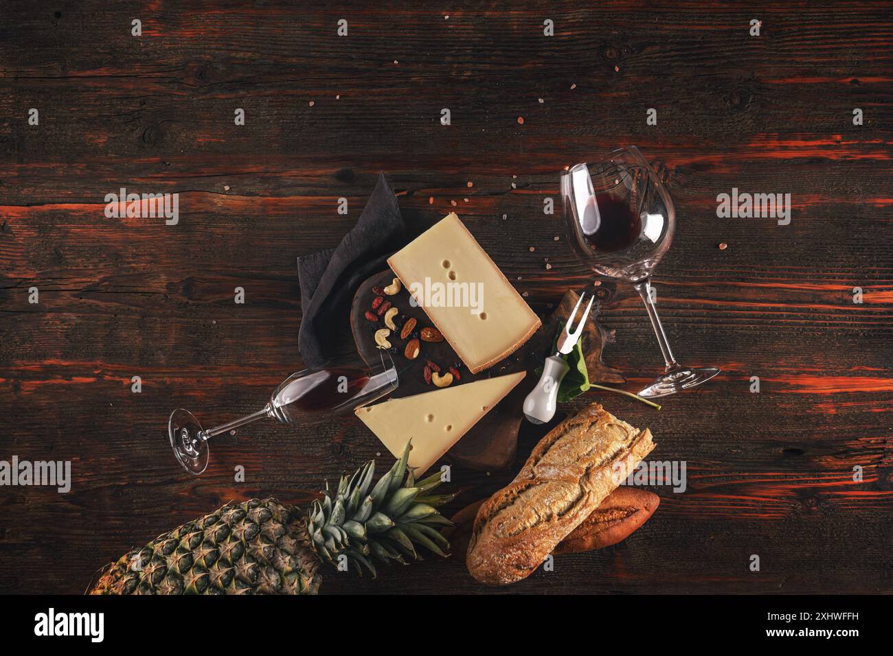 Plateau de fromage gastronomique accompagné de vin et de fruits sur une table en bois rustique Banque D'Images