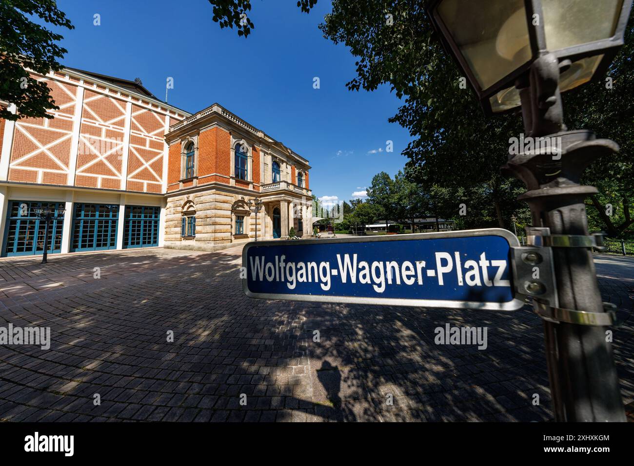 15 juillet 2024, Bavière, Bayreuth : « Wolfgang-Wagner-Platz » est écrit sur un panneau devant le Bayreuth Festspielhaus. Photo : Daniel Karmann/dpa Banque D'Images