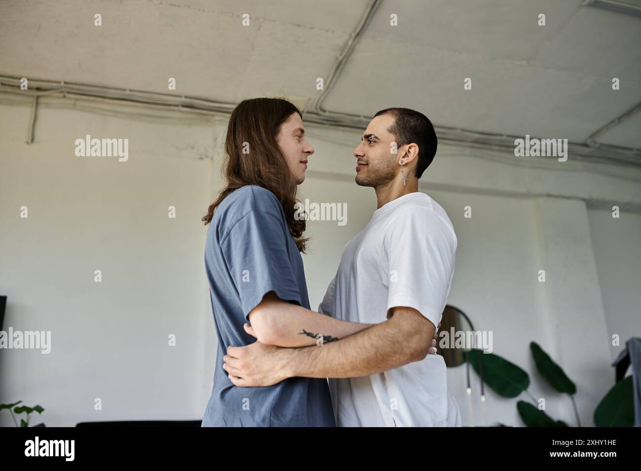 Un jeune couple gay s'embrasse dans une chambre, exprimant leur amour l'un pour l'autre. Banque D'Images