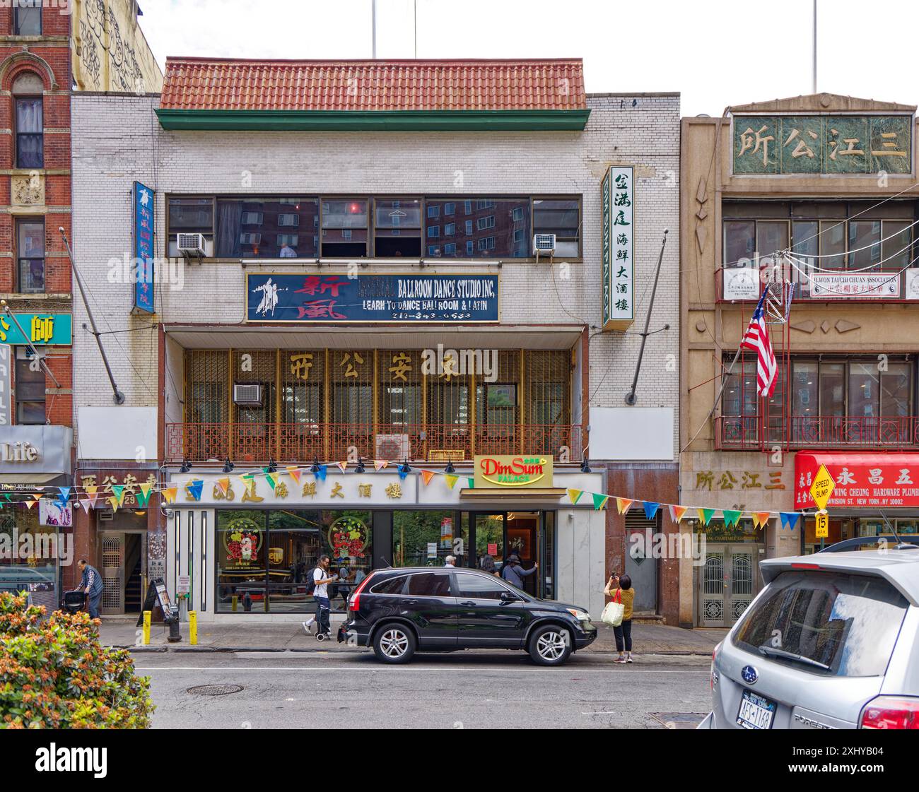 NYC Chinatown : club privé, studio de danse et restaurant occupent un bâtiment en briques blanches coiffé d'un toit en tuiles rouges de style pagode. Banque D'Images