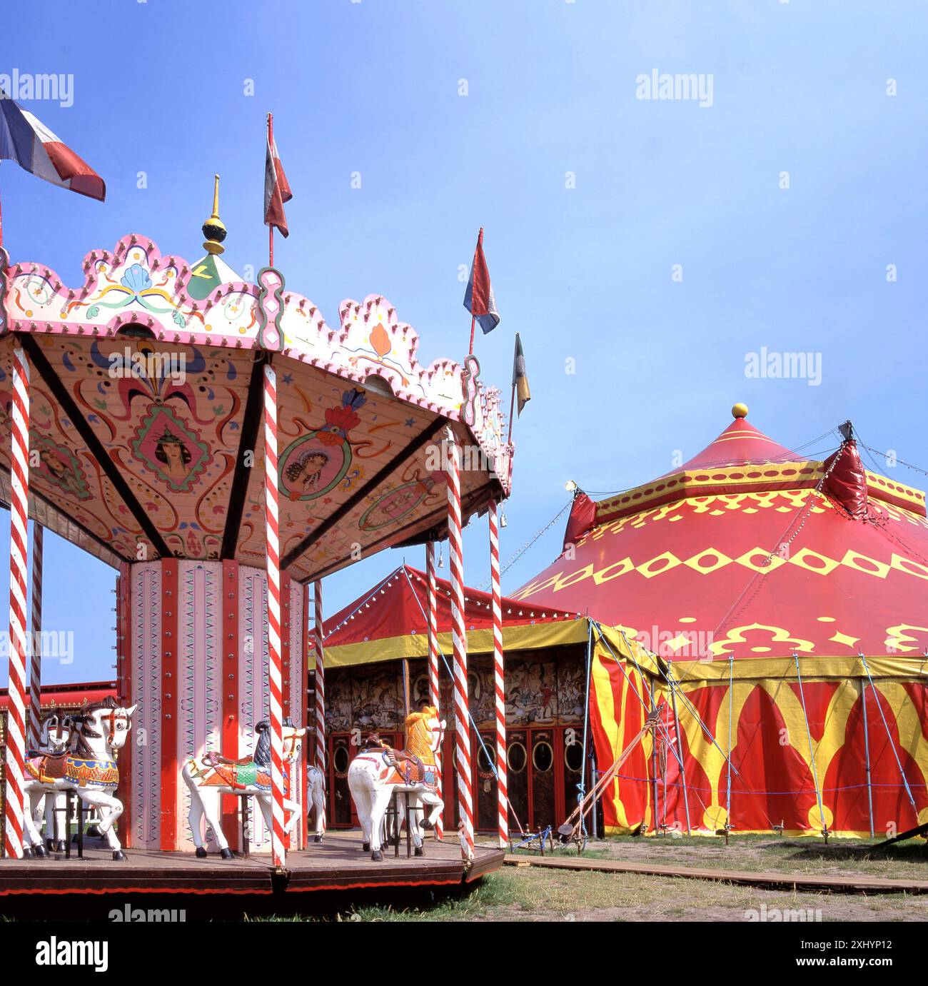 Carrousel traditionnel et tente de cirque par un matin ensoleillé à une foire en France Banque D'Images