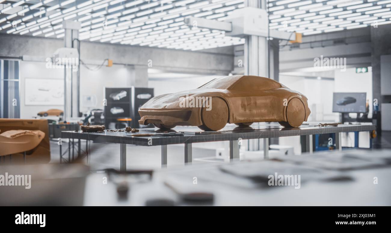 Concept car Industrial Plasticine Clay Model debout sur une table dans un studio créatif vide sans personnes. Agence de recherche et développement à l'usine de production de véhicules prototypes. Prise de vue en cours Banque D'Images