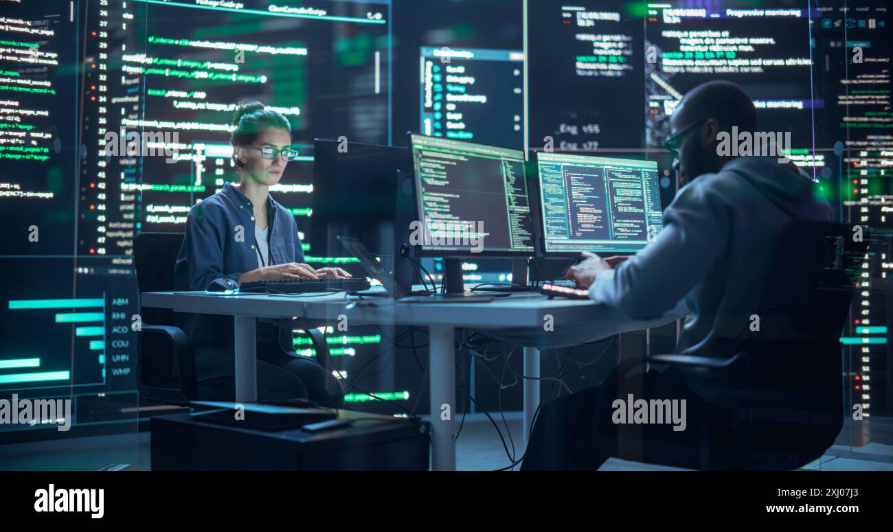 Portrait de deux développeurs divers travaillant sur l'ordinateur, en tapant des lignes de code qui apparaissent sur les grands écrans qui les entourent. Programmeurs masculins et féminins créant ensemble des logiciels innovants, corrigeant des bugs Banque D'Images