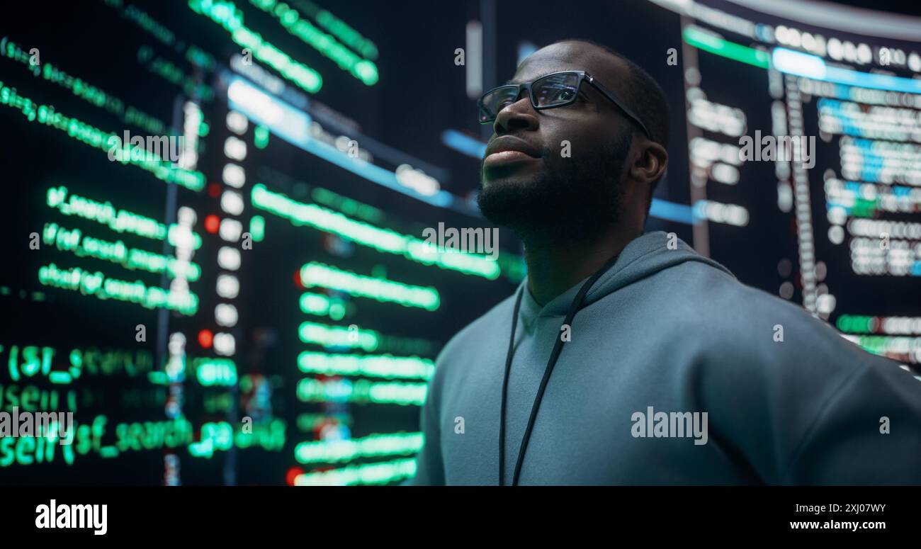 Portrait de programmeur professionnel inquiet fixant un bogue, traitant avec Crashing System. Jeune homme noir regardant de grands écrans numériques glitching tout en affichant des lignes de code, pensant à des solutions Banque D'Images