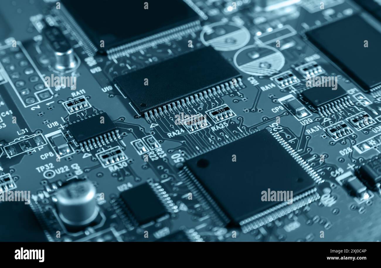 Gros plan détaillé d'une carte de circuit électronique présentant des micropuces, des résistances et d'autres composants, représentant la technologie et le matériel modernes. Banque D'Images