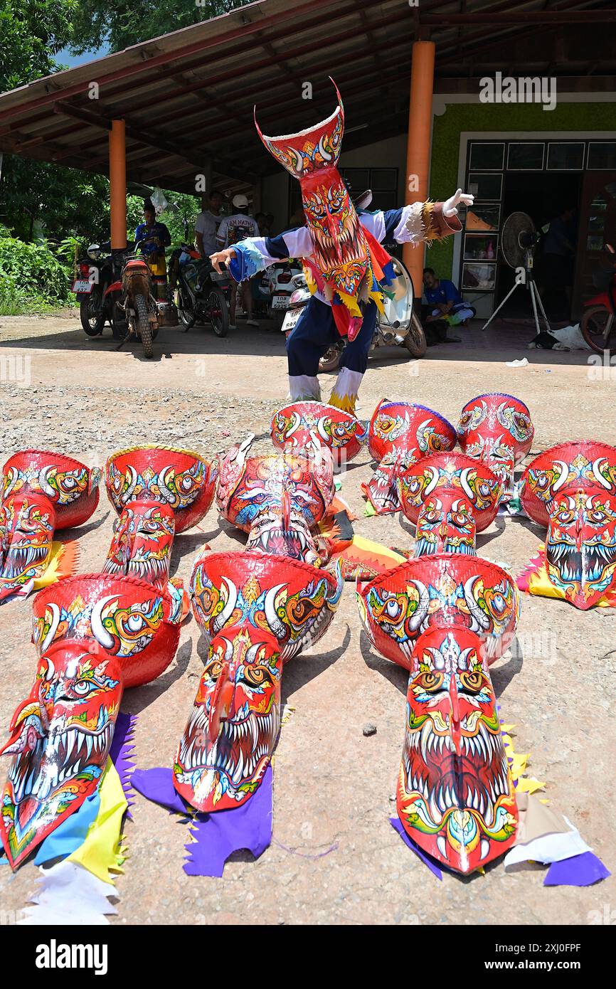 Homme posant avec des masques « fantômes » traditionnels fabriqués à partir de tiges de feuilles de palmier et de paniers en osier de bambou pour le festival annuel Phi Ta Khon à Dan SAI, Thaïlande Banque D'Images