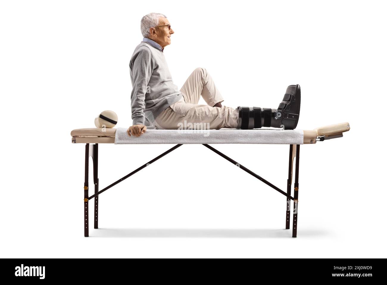 Homme âgé avec attelle orthopédique du pied assis isolé sur fond blanc Banque D'Images Homme âgé avec attelle orthopédique du pied assis isolé sur fond blanc Banque D'Images