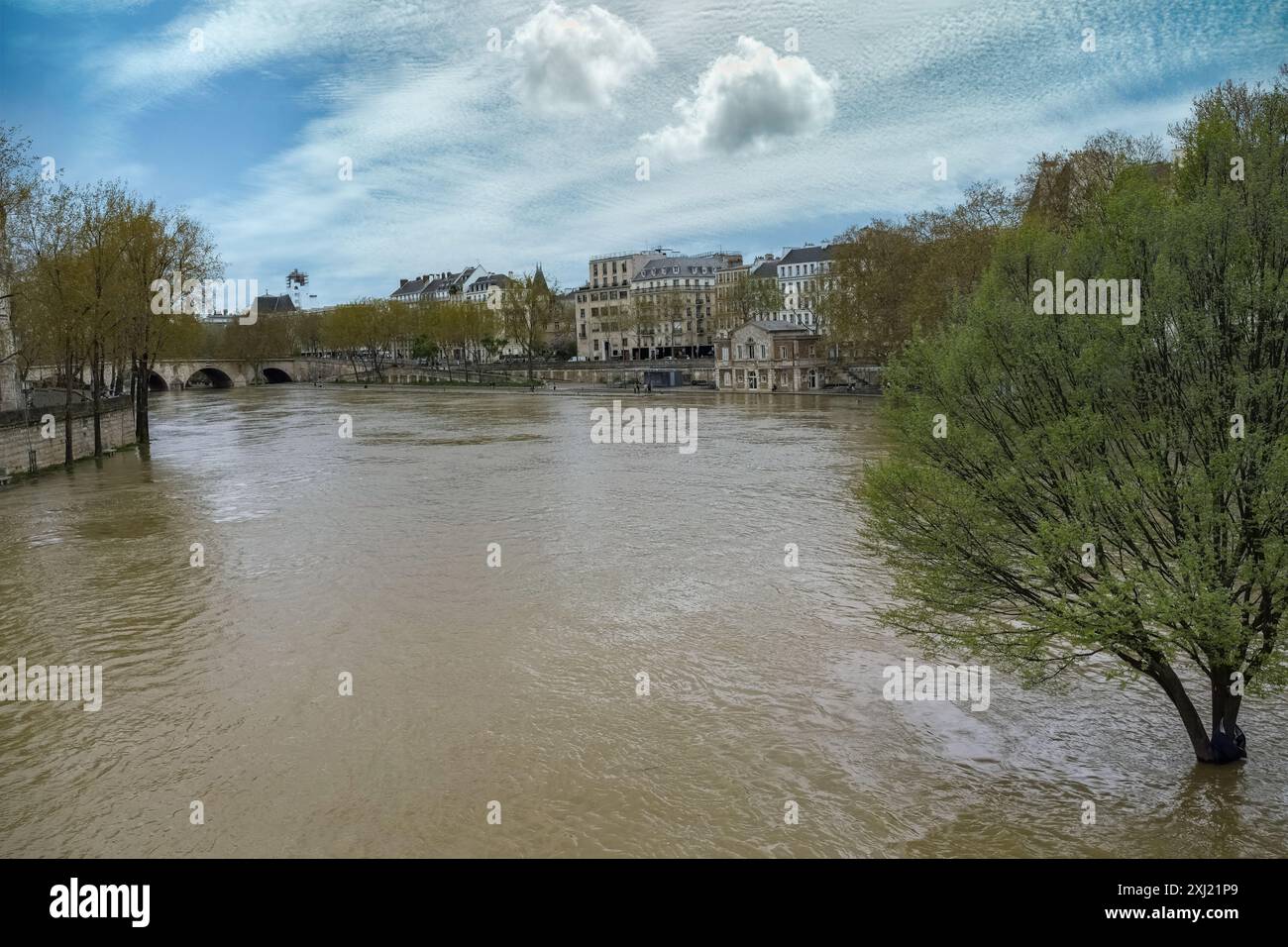 Une vue panoramique sur la Seine à Paris avec des bâtiments et un pont sous un ciel partiellement nuageux Banque D'Images Une vue panoramique sur la Seine à Paris avec des bâtiments et un pont sous un ciel partiellement nuageux Banque D'Images