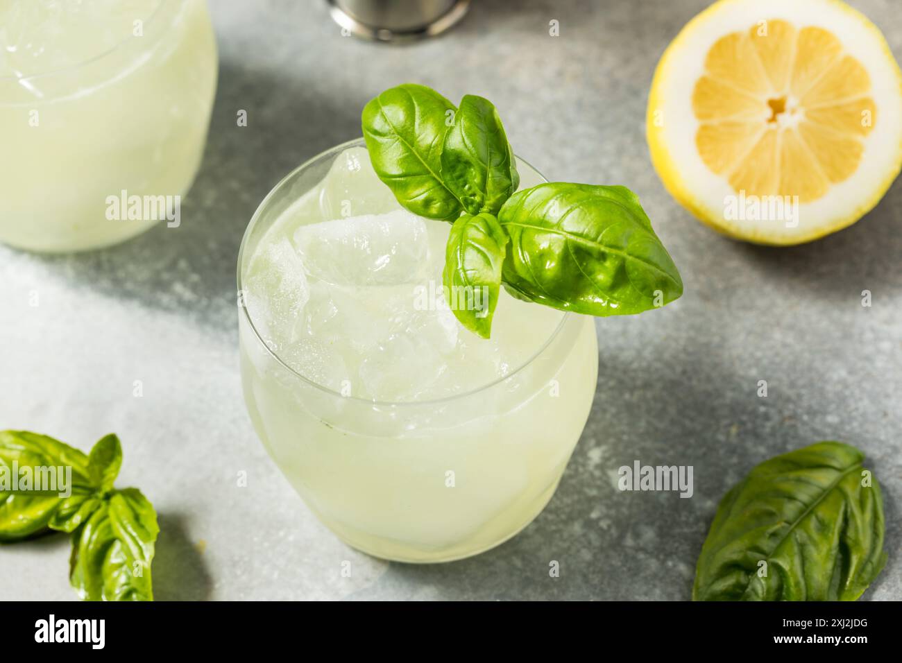 Rafraîchissant Boozy Basil Gin Smash avec citron vert Banque D'Images