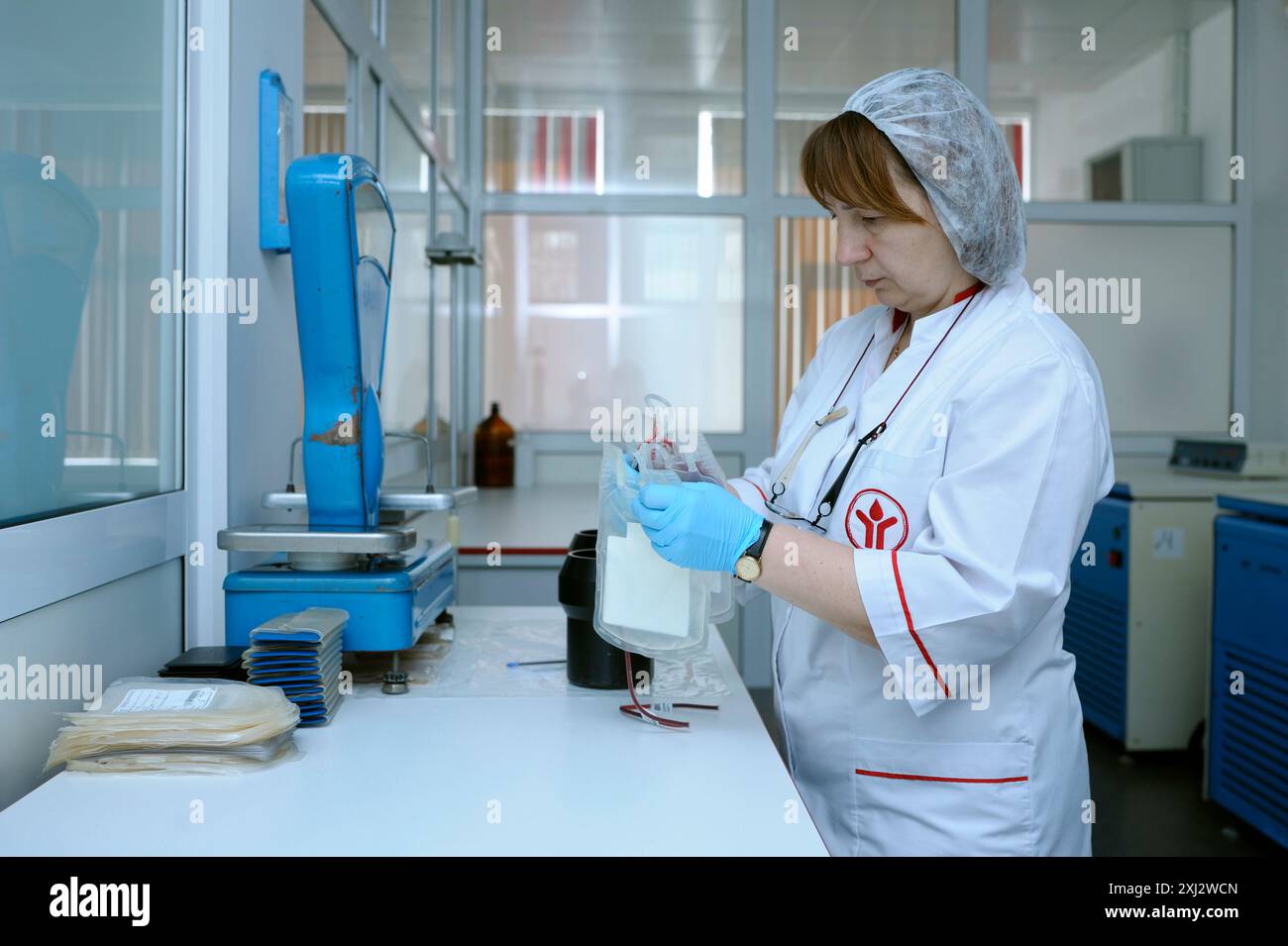 Infirmière debout devant une table avec balance contenant des récipients contenant du sang pour peser. Laboratoire de la station de transfusion sanguine de la ville (municipale). Avril Banque D'Images