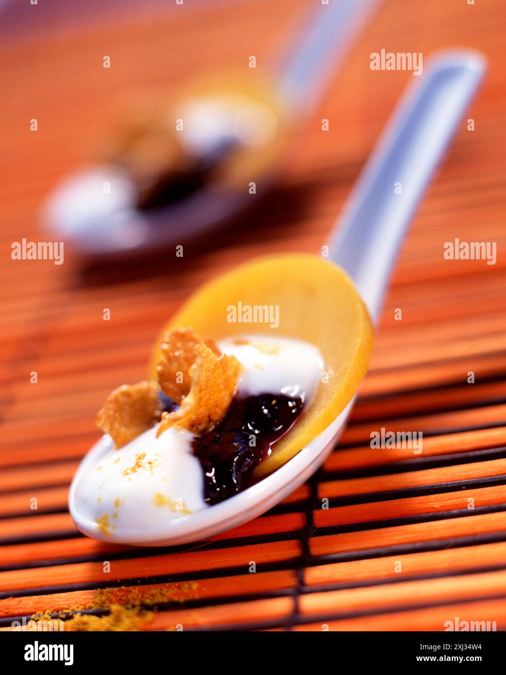 Cuillerée de mascarpone avec mûres, céréales et curry doux Banque D'Images