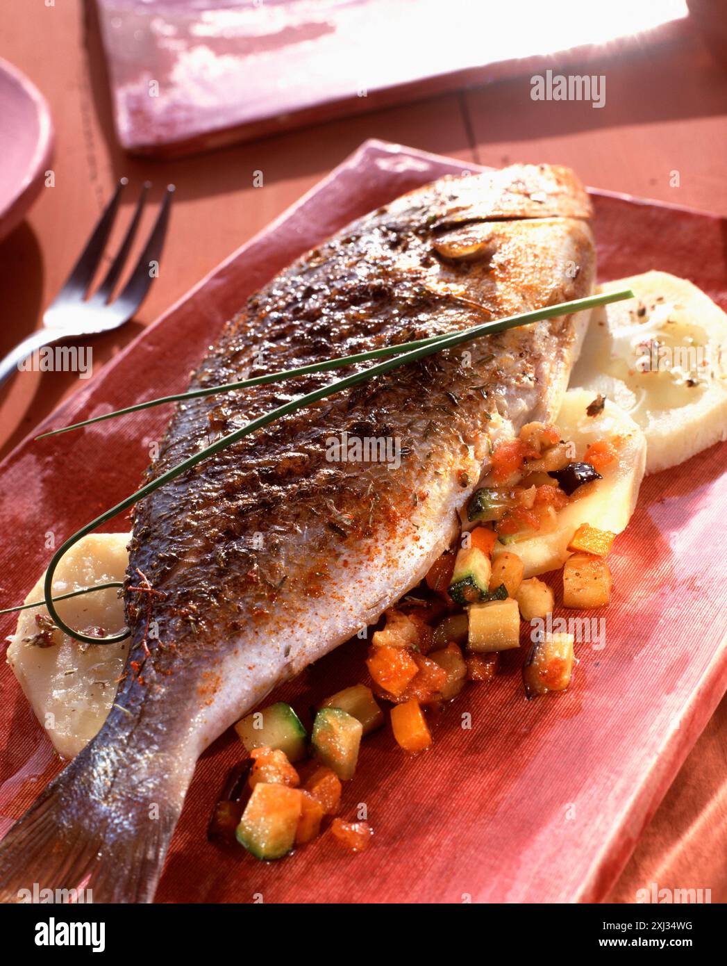 Dorade grillée aux épices sur pommes de terre (thème : poissons et crustacés grillés) Banque D'Images