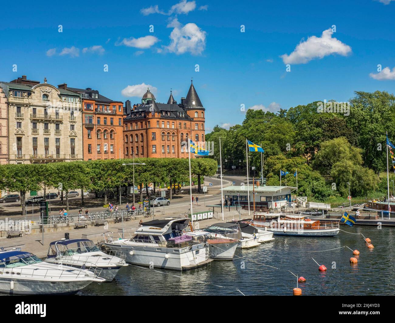 Paysage urbain de front de mer avec des bateaux et des bâtiments historiques, décoré de drapeaux et d'arbres, stockholm, suède Banque D'Images
