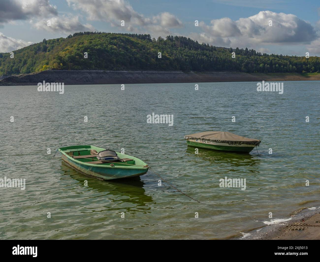 Deux bateaux verts flottant sur un lac, entourés de forêts tranquilles et d'un ciel nuageux, waldeck, hesse, allemagne Banque D'Images