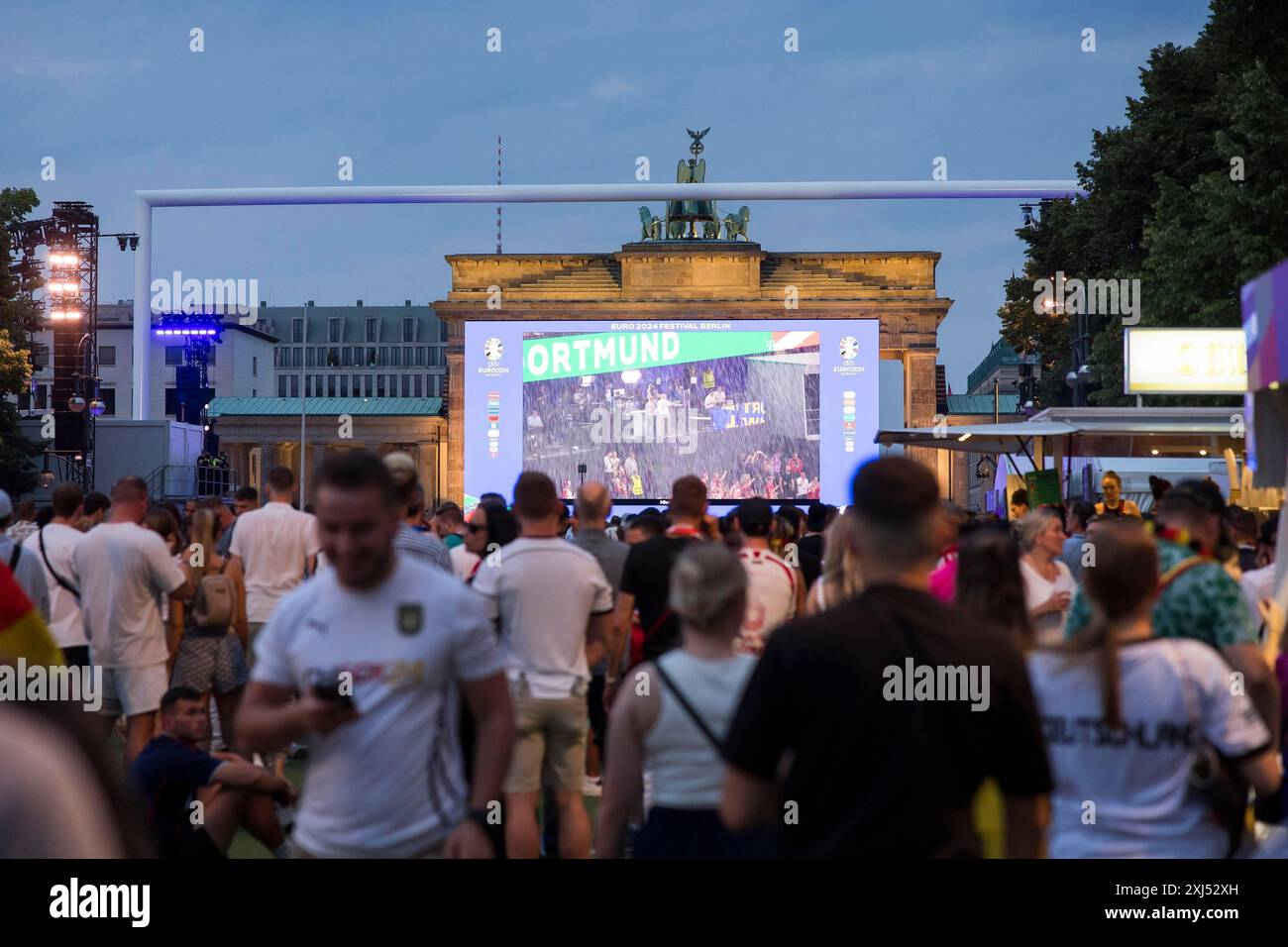 Les fans de Fassball célèbrent et rassemblent des informations dans la zone des fans au Brandenburg Tor après l'interruption de la manche du 16 match entre l'Allemagne Banque D'Images