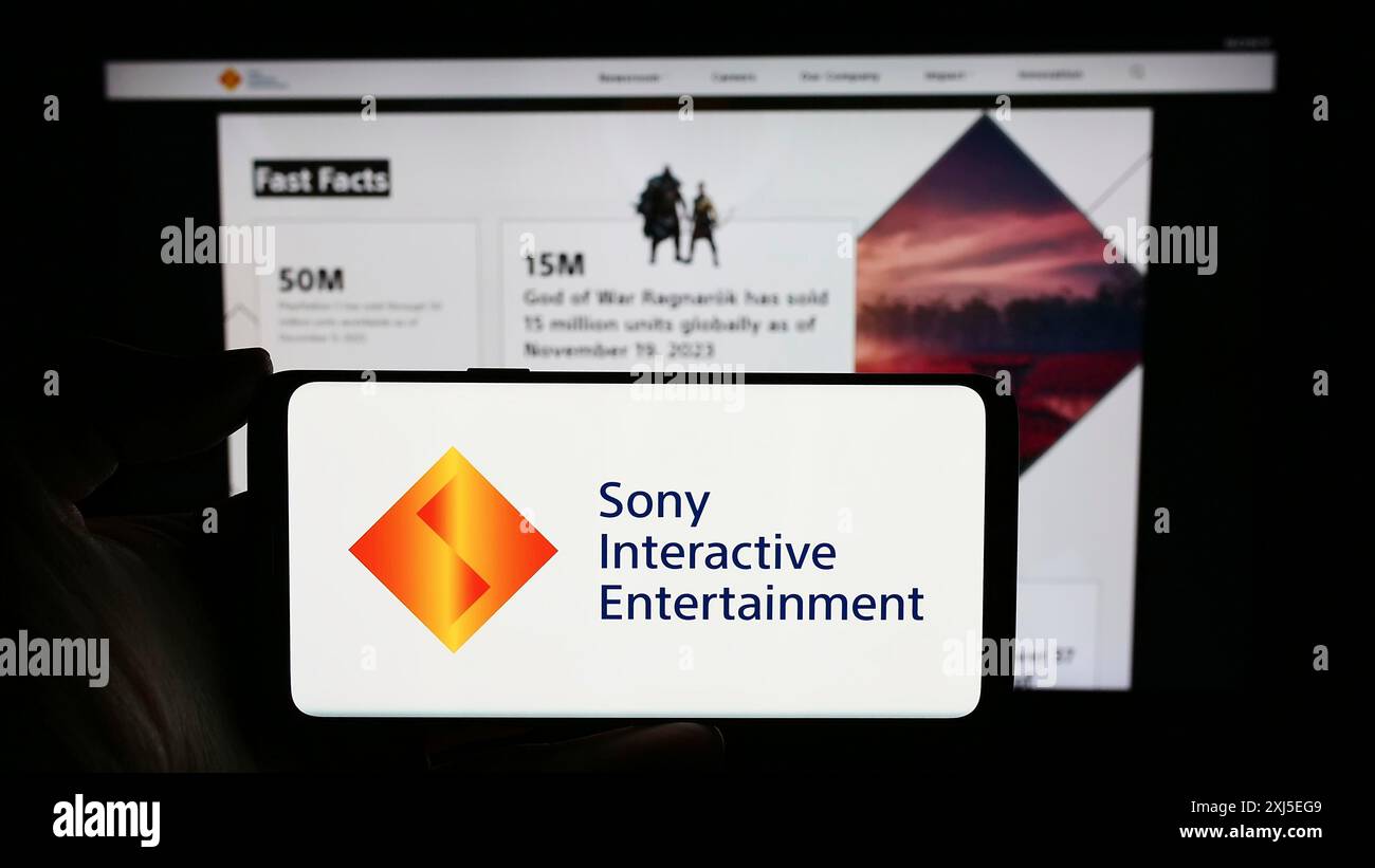 Stuttgart, Allemagne, 02-14-2024 : personne tenant un téléphone portable avec le logo de la société américaine de jeux vidéo Sony Interactive Entertainment LLC devant Banque D'Images