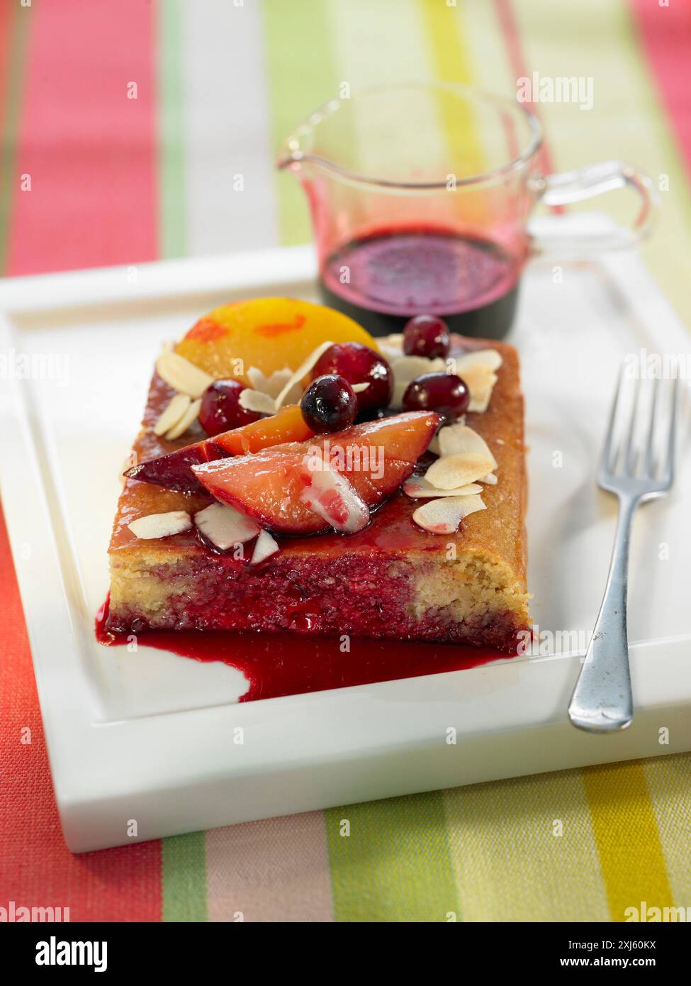 Portion de tarte aux prunes, aux amandes et aux cerises avec sirop d'hibiscus Banque D'Images