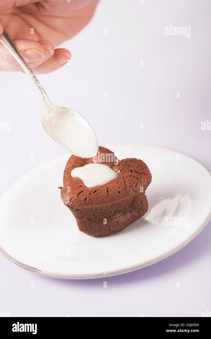 Fondant au chocolat en forme de coeur avec crème Banque D'Images