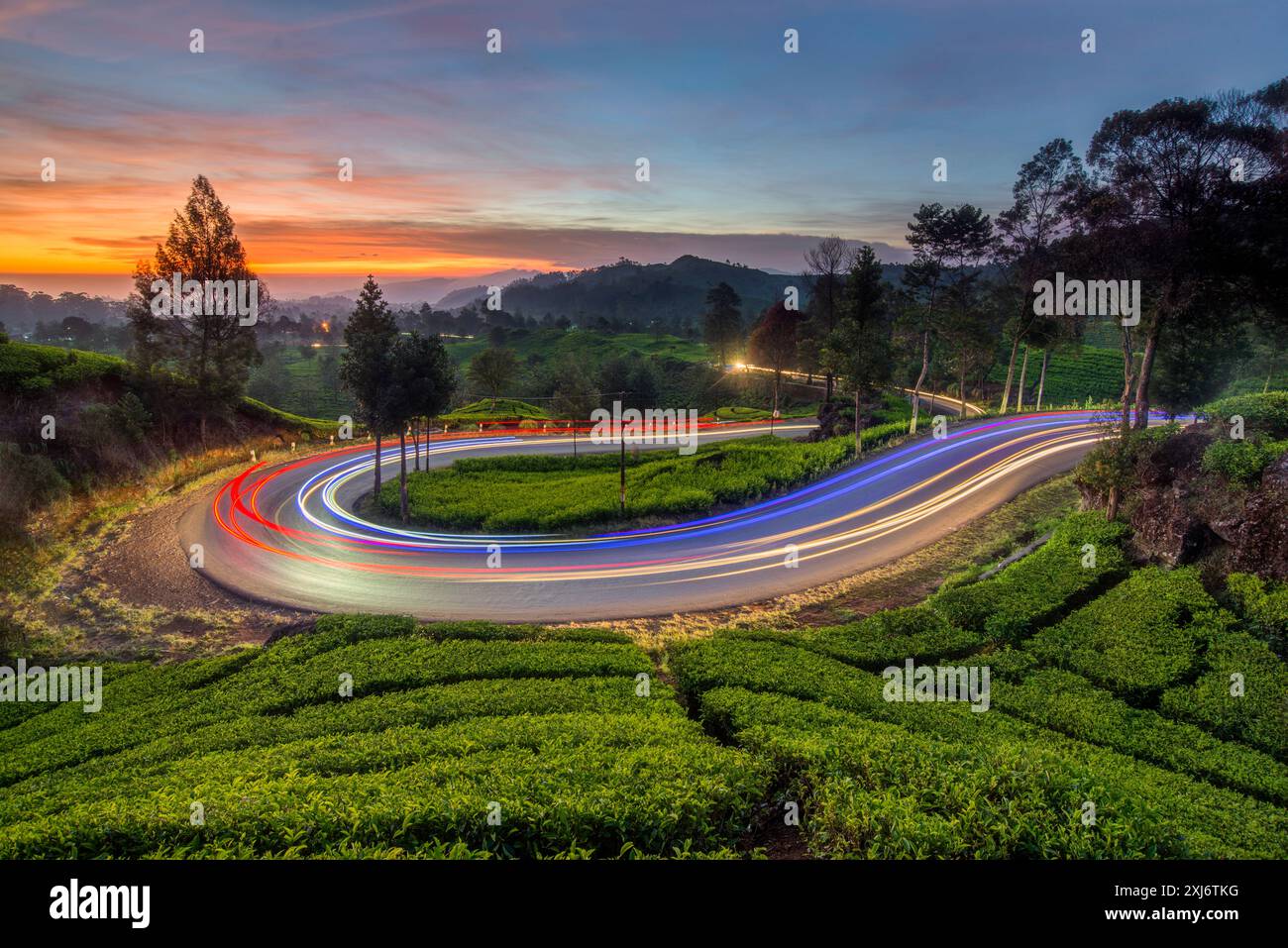 Sentiers légers sur une route de montagne sinueuse au coucher du soleil, Java Ouest, Indonésie Banque D'Images